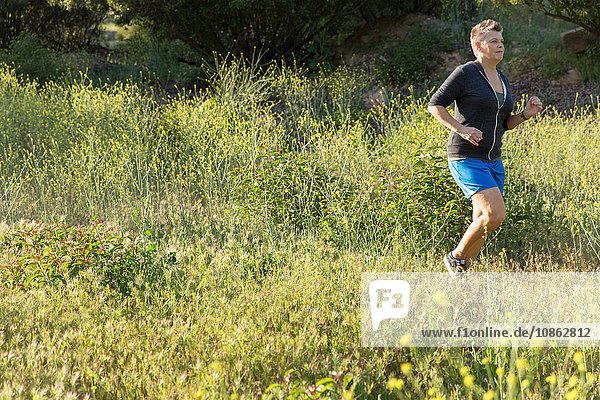 Frau joggt auf Wildblumenwiese