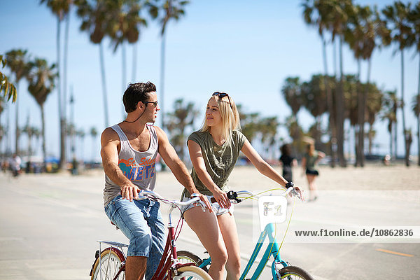 Couple cycling together at Venice Beach  Los Angeles  California  USA