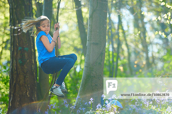 Girl swinging through tree's in bluebell forest  Hallerbos  Brussels  Belgium
