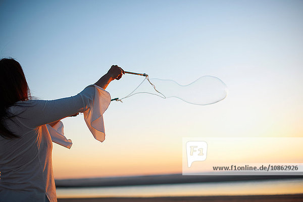 Frau macht Seifenblasen am Cannon Beach bei Sonnenuntergang  Kalifornien  USA