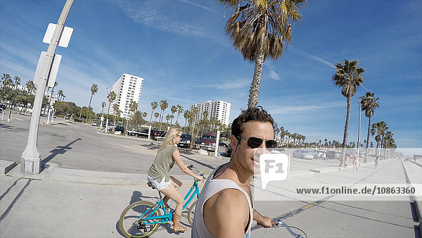 Man taking selfie cycling at Venice Beach California USA