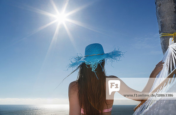 Rückansicht einer jungen Frau  die aus der Hängematte am Strand von Miami  Florida  USA  schaut