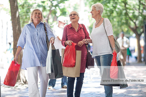 Ältere und reifere Frauen schlendern mit Einkaufstaschen in der Stadt