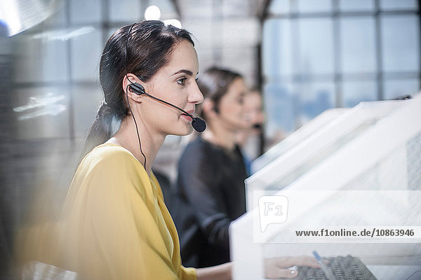 Row of female telephonists advising in call centre
