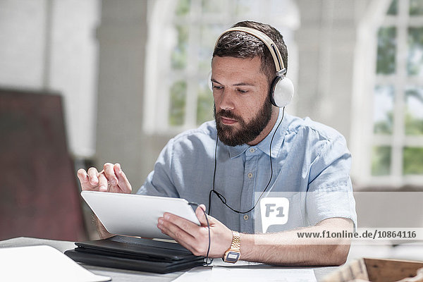 Man using digital tablet with headphones