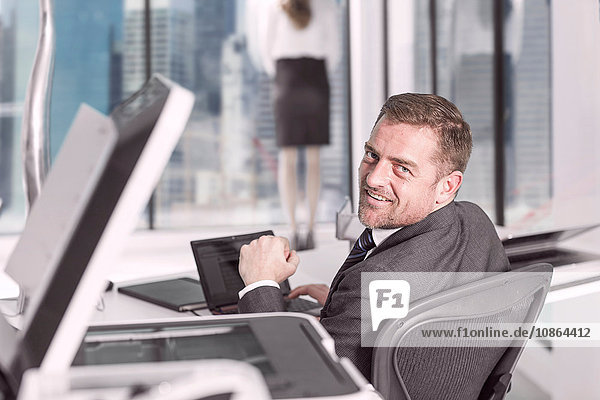 Geschäftsmann schaut vom Laptop im Büro auf