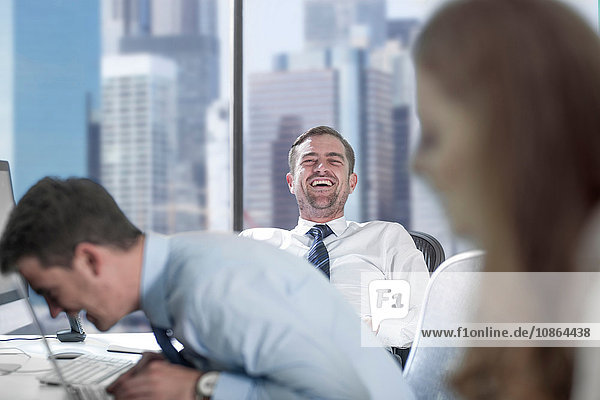 Businessmen laughing in office
