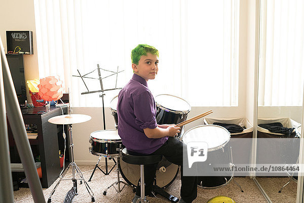 Junge spielt Schlagzeug im Schlafzimmer