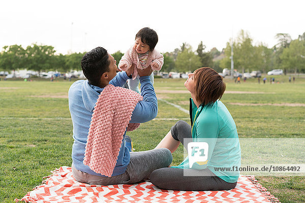 Paar spielt mit Baby im Park