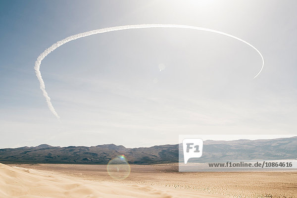 Wüstenlandschaft und halbkreisförmige Kondensstreifen bei blauem Himmel  Olancha  Kalifornien  USA