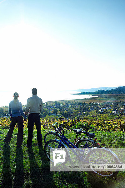 Cycling couple looking out over vineyards and Lake Balaton  Budapest Hungary