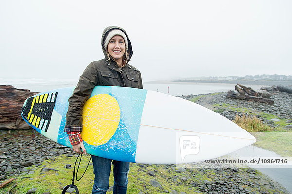 Porträt einer Surferin mit Surfbrett an der Küste  Seaside  Oregon  USA