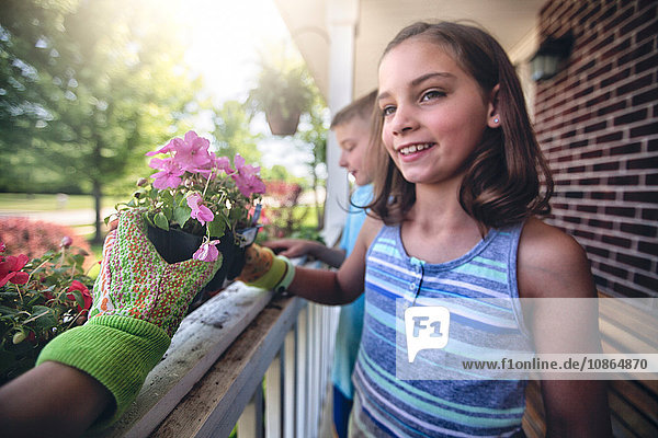 Hand tragender Gartenhandschuh  der Pflanzen an Jungen und Mädchen weitergibt