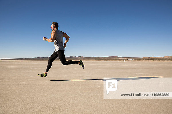Man training  running on dry lake bed  El Mirage  California  USA