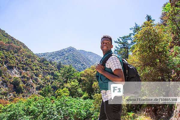 Young male hiker looking over his shoulder in landscape  Arcadia  California  USA