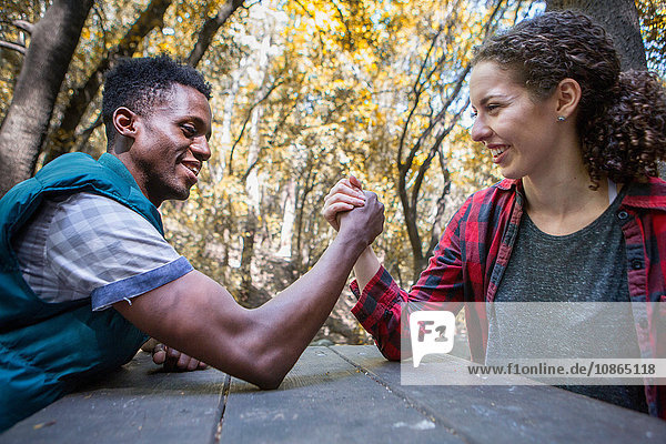 Junge Wanderin beim Armdrücken mit ihrem Freund am Waldpicknicktisch  Arcadia  Kalifornien  USA