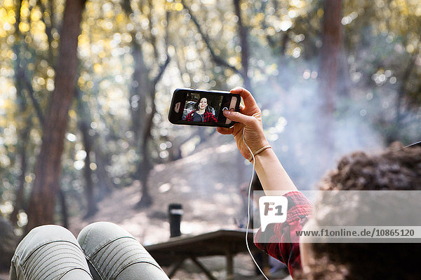 Über-die-Schulter-Ansicht einer jungen Wanderin  die mit ihrem Smartphone im Wald unterwegs ist  Arcadia  Kalifornien  USA