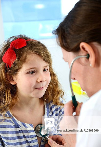 Krankenhausarzt  der die Brust eines Mädchens mit einem Stethoskop untersucht