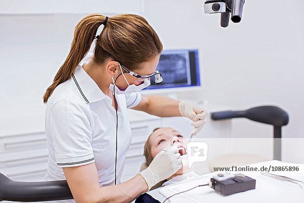 Zahnarzt in Zahnklinik führt zahnärztliche Untersuchung an junger Frau durch
