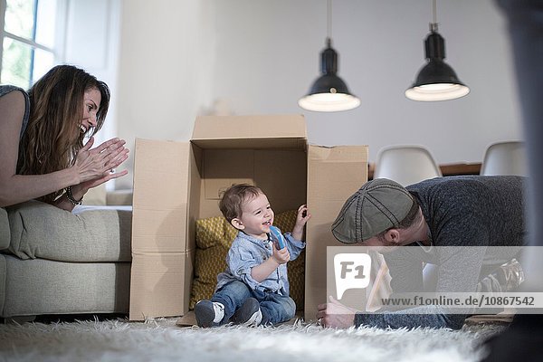 Parents playing with baby boy and cardboard box