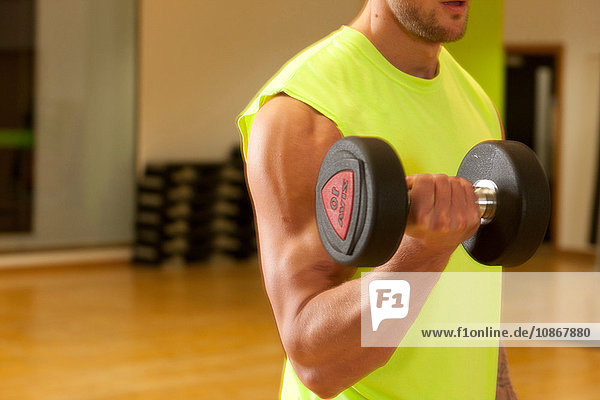 Man in gym using dumbbell
