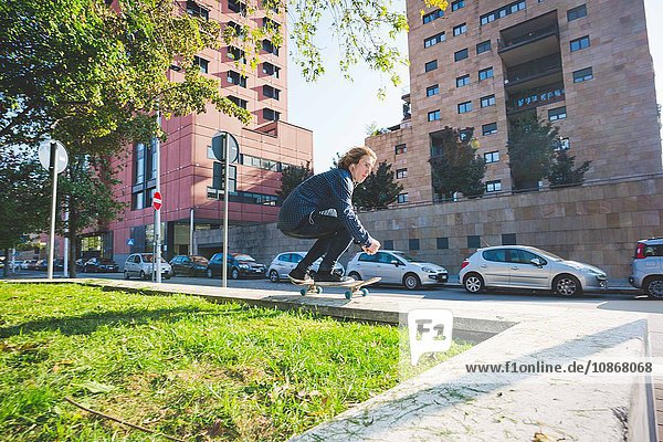 Junge männliche Skateboarder Skateboarder an der Stadtmauer