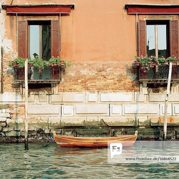 Ein kleines hölzernes Ruderboot vertäut auf einem Kanal in Venedig Italien
