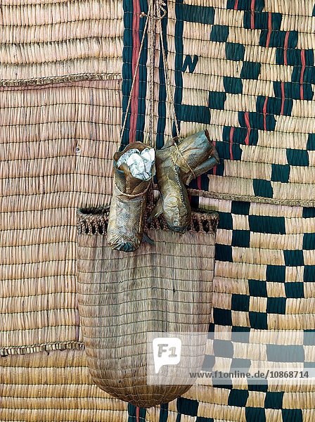 Traditionelle Ainu-Tasche und Schuhe hängen im Ainu-Museum am Porotosee. Das Volk der Ainu ist in Japan und Russland beheimatet. Hokkaido Japan