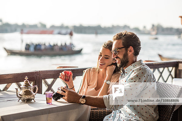 Romantic couple reviewing camera at Dubai marina cafe  United Arab Emirates