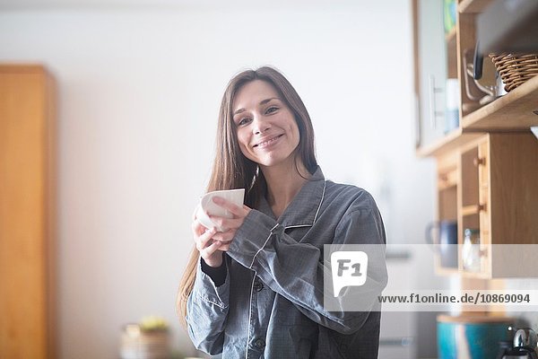 Young woman at home  holding hot drink
