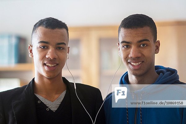 Porträt der Zwillingsbrüder  die sich Kopfhörer teilen
