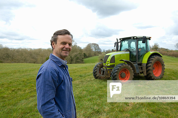 Portrait of farmer in field in front of tractor