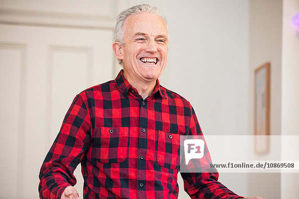 Porträt eines glücklichen älteren Mannes mit rot kariertem Hemd