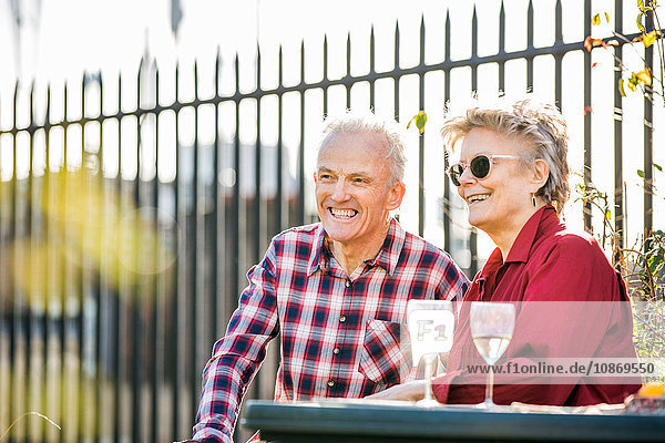 Seniorenpaar auf dem Dachgarten der Stadt entspannt sich bei Weißwein