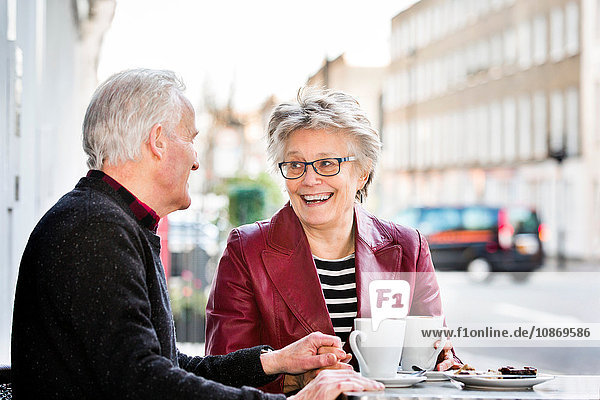 Romantisches Seniorenpaar im Straßencafé beim Händchenhalten