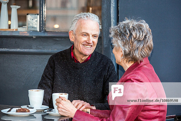 Älteres Ehepaar im Straßencafé  das Kaffee trinkt und plaudert