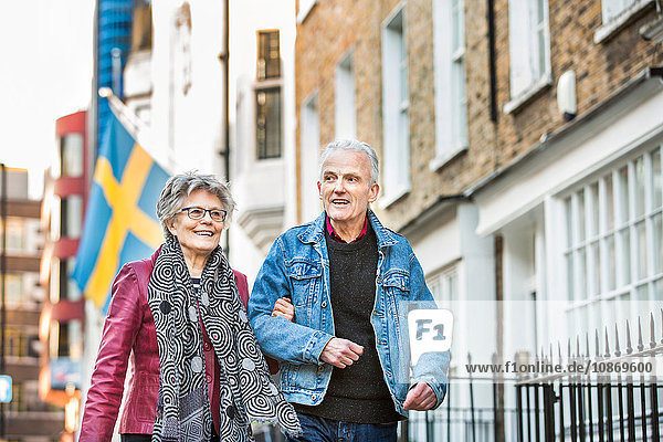 Älteres Ehepaar schlendert Arm in Arm durch die Stadt