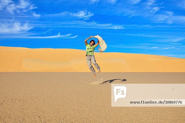Mittelgroßer erwachsener Mann beim Springen  Großes Sandmeer  Ägypten  Afrika