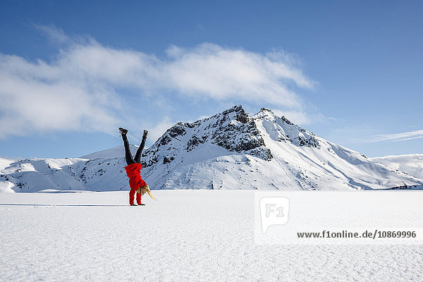 Woman doing handstand on snow-covered field Litla-heidi Iceland