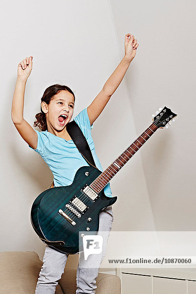 Mädchen mit Gitarre  Mund offen  Arme im Triumph erhoben