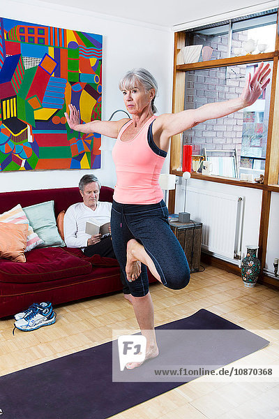 Frau praktiziert Yoga zu Hause