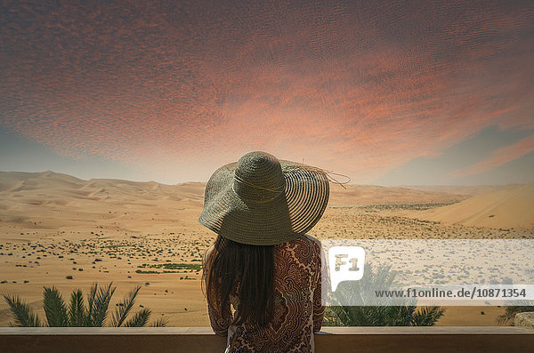 Frau auf dem Balkon  Blick auf die Wüste  bei Sonnenuntergang  Rückansicht  Abu Dhabi  Emirat Abu Dhabi  Vereinigte Arabische Emirate