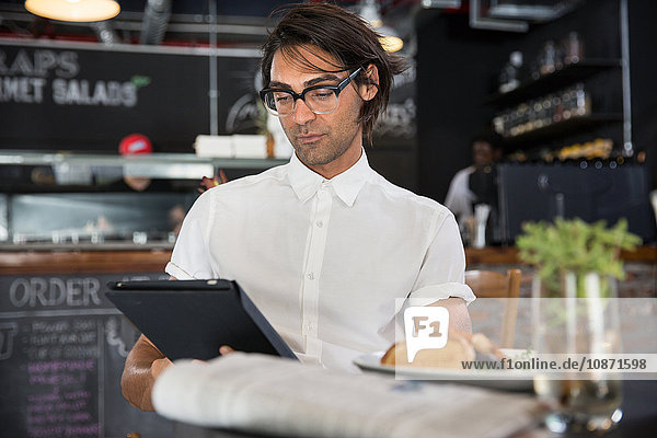 Man in coffee shop using digital tablet