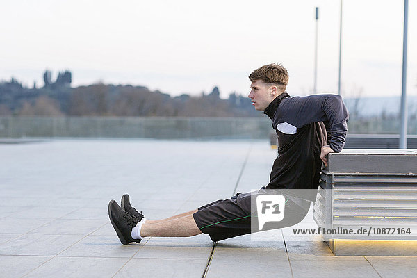 Young man exercising outdoors  stretching