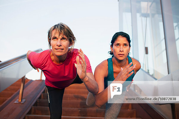 Zwei Frauen trainieren  balancieren auf einem Bein auf einer Treppe