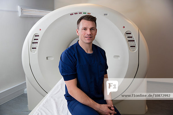 Porträt eines Arztes neben einem CT-Scanner