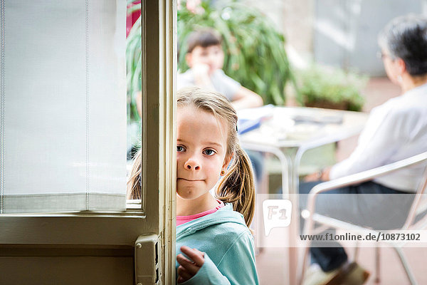 Mädchen schaut durch die Tür eines Cafés  Florenz  Italien