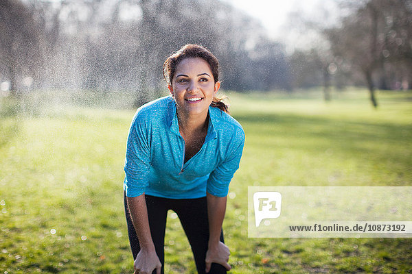 Portrait of young woman taking training break in park