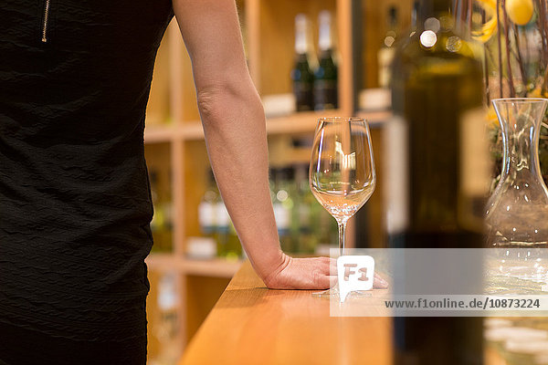 Cropped view of woman in wine shop with wine glass