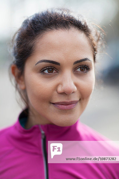 Portrait of young woman wearing pink tracksuit top for training